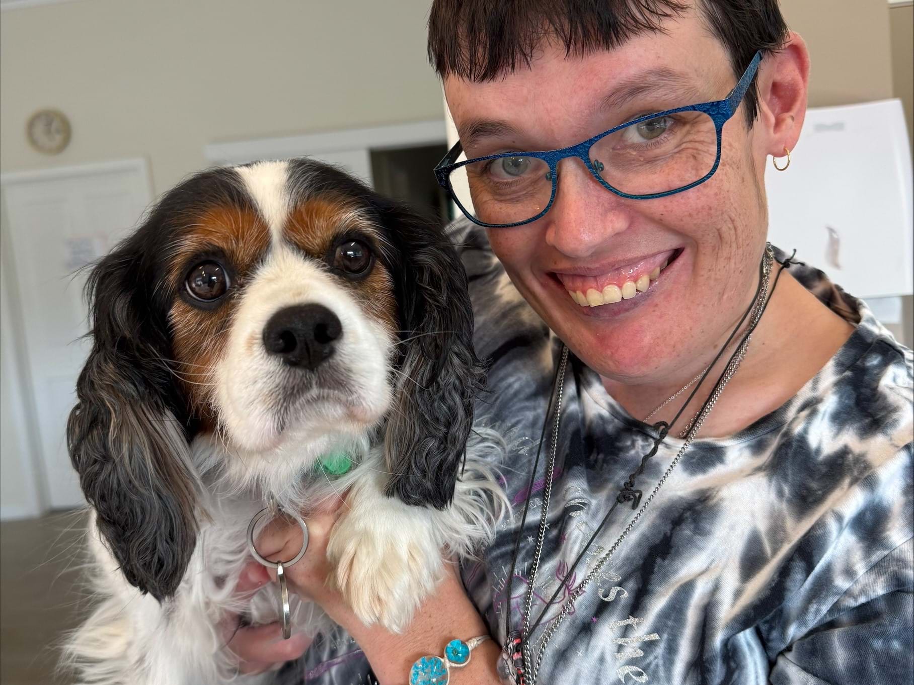 A woman smiles with a dog on her lap at Pets and pet care at Distinctive Options Noweyung