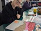 A man smiling while working with modelling clay Art at Distinctive Options Noweyung