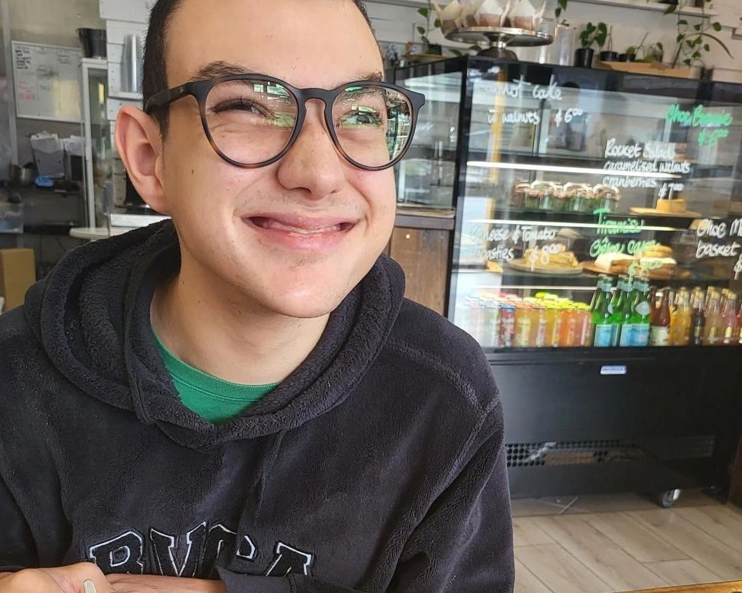 A young man in a cafe with NDIS Independent Living Supports disability Distinctive Options
