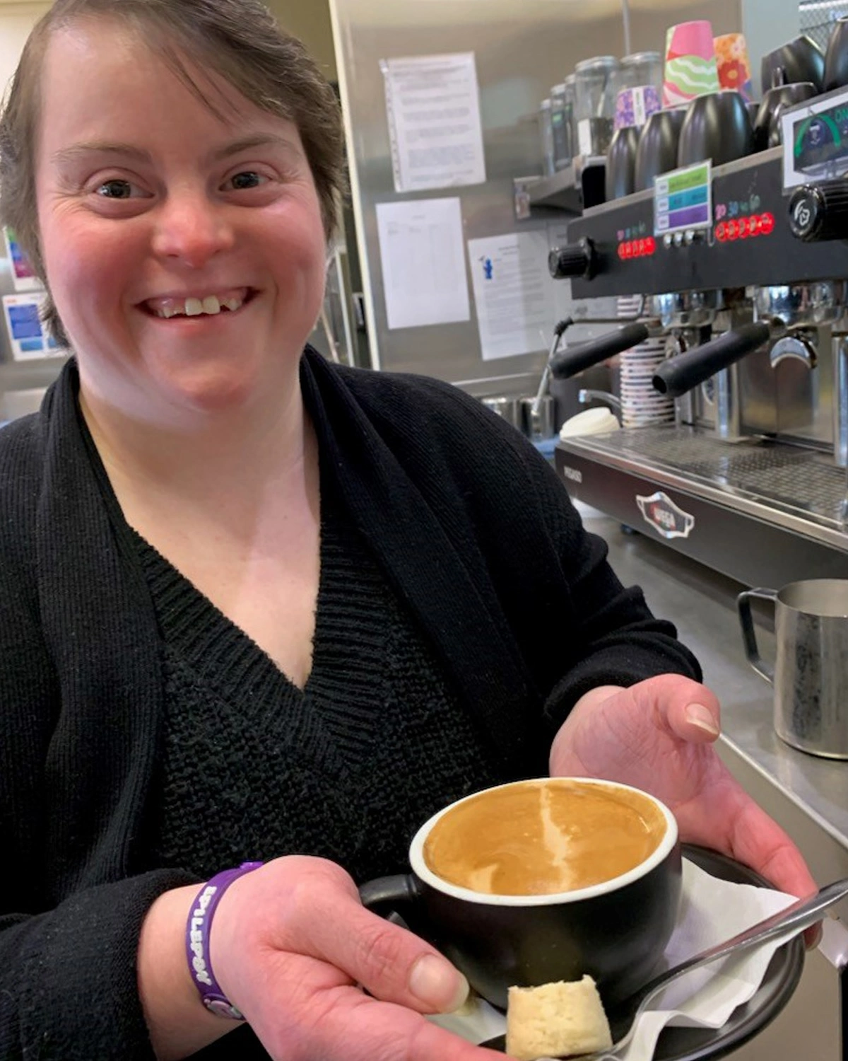 Brew Crew Cafe Staff holding a cup of cappucino