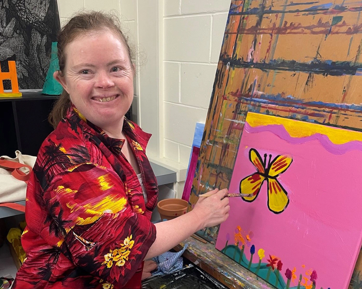 A woman paints at Group Supports Colour Gang at Distinctive Options Noweyung