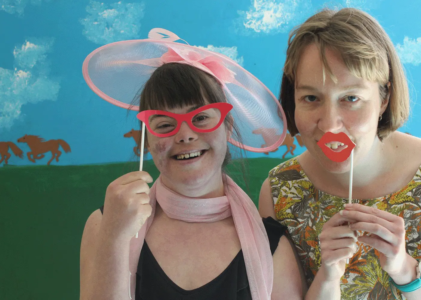 Two women dress in formal wear as if they are attending the Melbourne Cup horse race