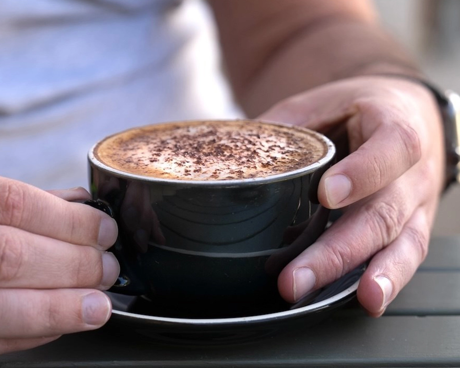 a pair of hands hold a cup of coffee at Extended hours at Distinctive Options Noweyung