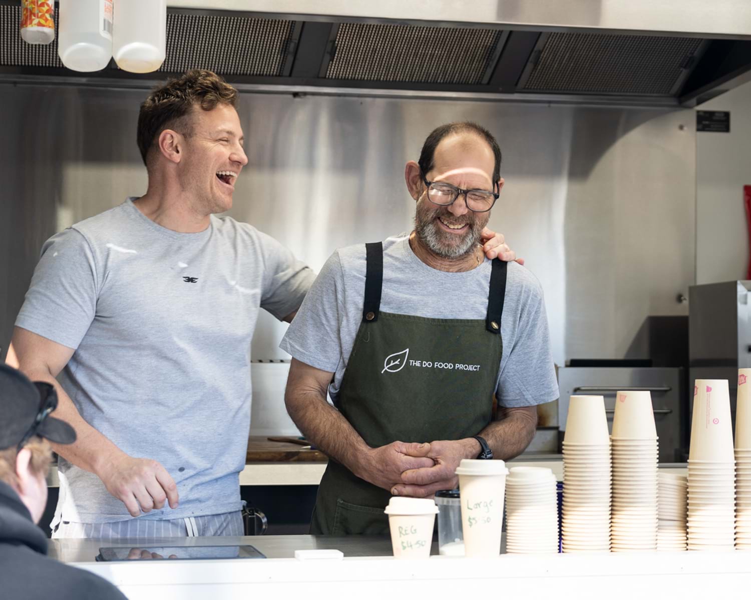 Kevin and Peter behind the counter at the DO Food Project Mobile Trailer 