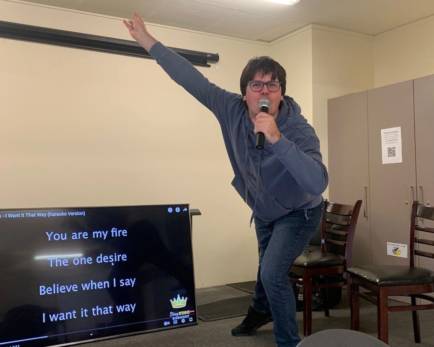 A man sings energetically with microphone at Karaoke at Distinctive Options Noweyung Bairnsdale