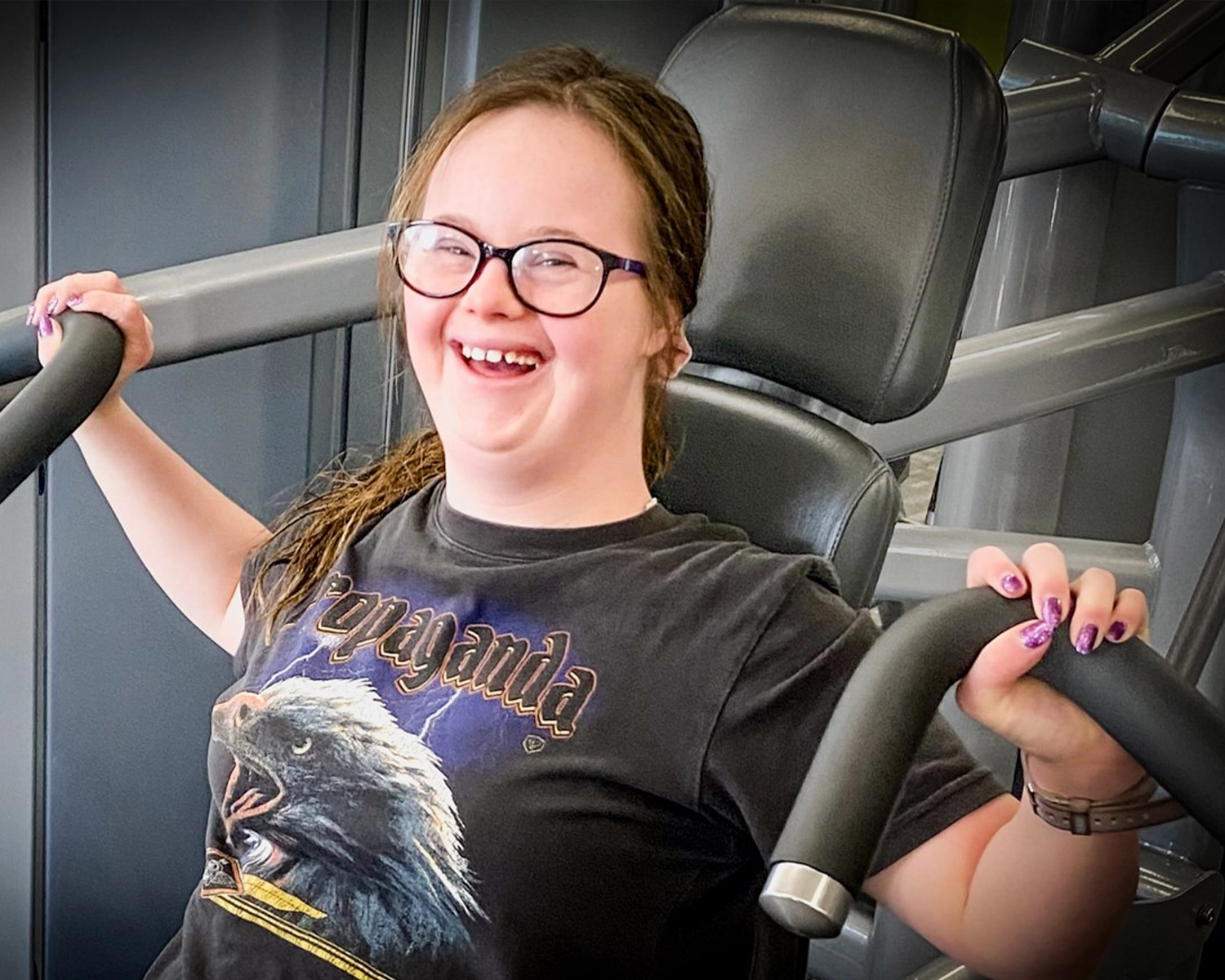 A woman lifts weights in a gym at NDIS registered disability service Distinctive Options