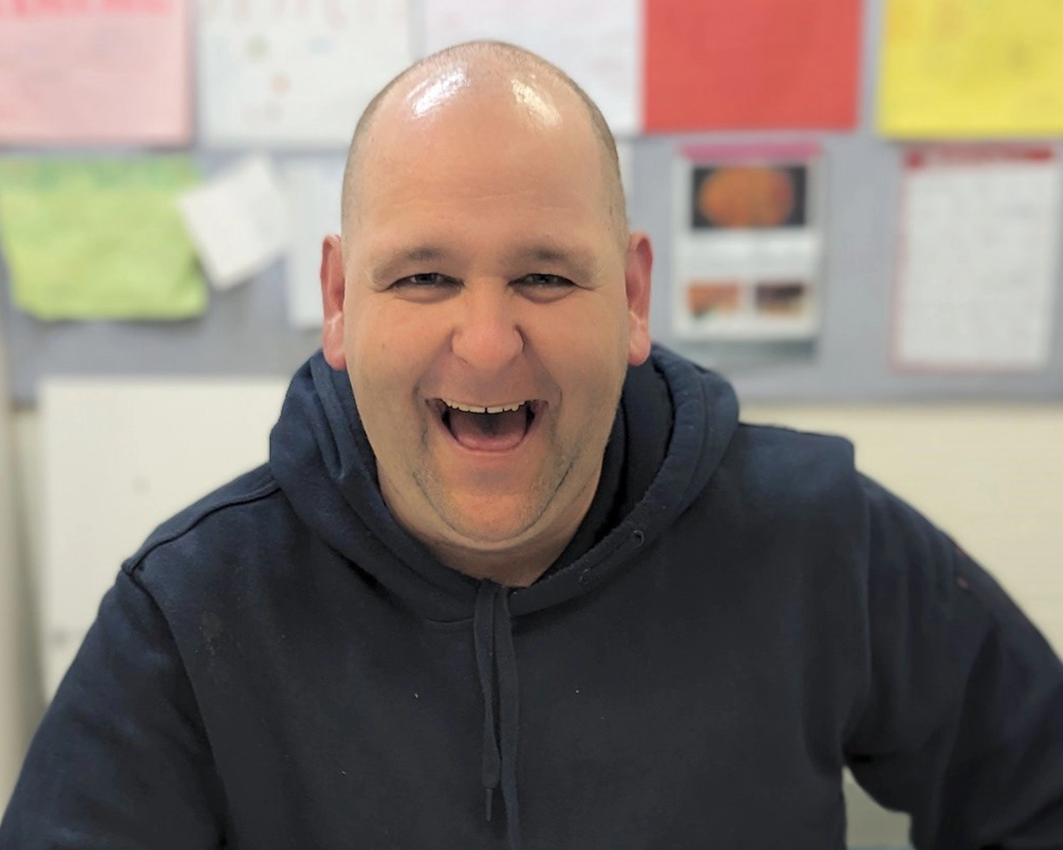 A man smiles at Group Supports Movie and Pizza at Distinctive Options Noweyung