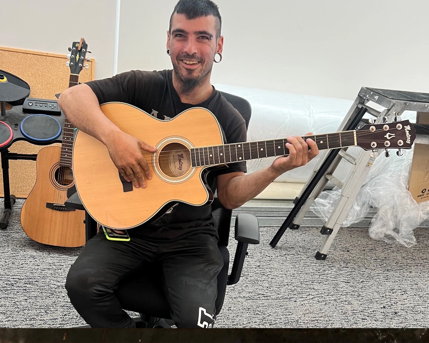 A man plays guitar at music activity at Distinctive Options Brimbank