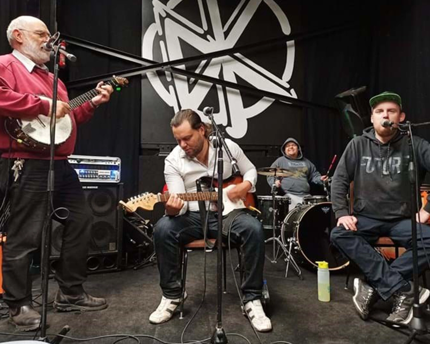 A group of people play music on stage at NDIS registered disability service Distinctive Options