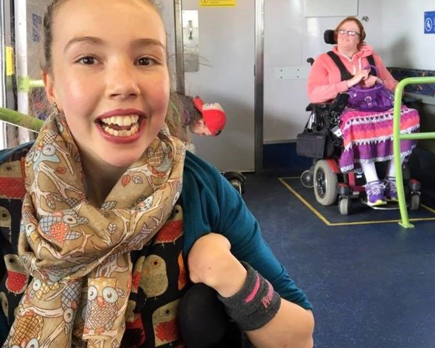 Two women using wheelchairs travel on a train at NDIS registered disability service Distinctive Options