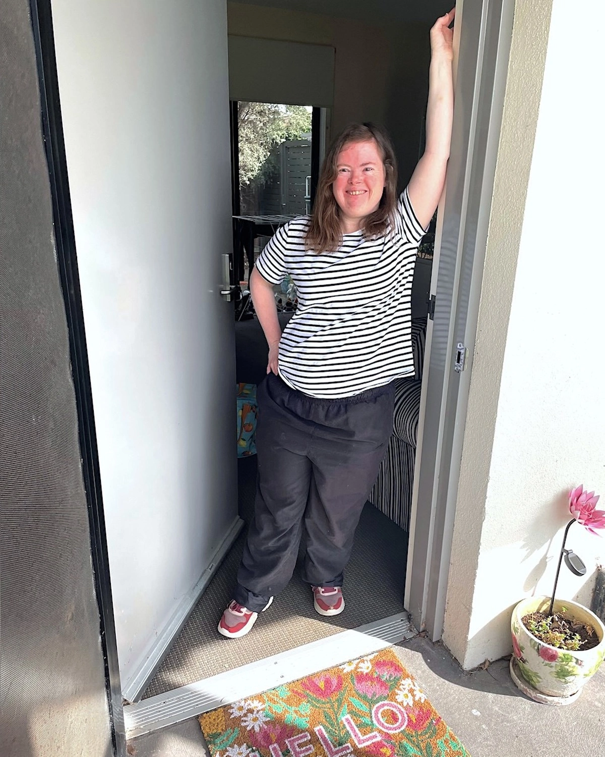 A woman stands at a doorway at NDIS registered disability service Distinctive Options Supported accommodation