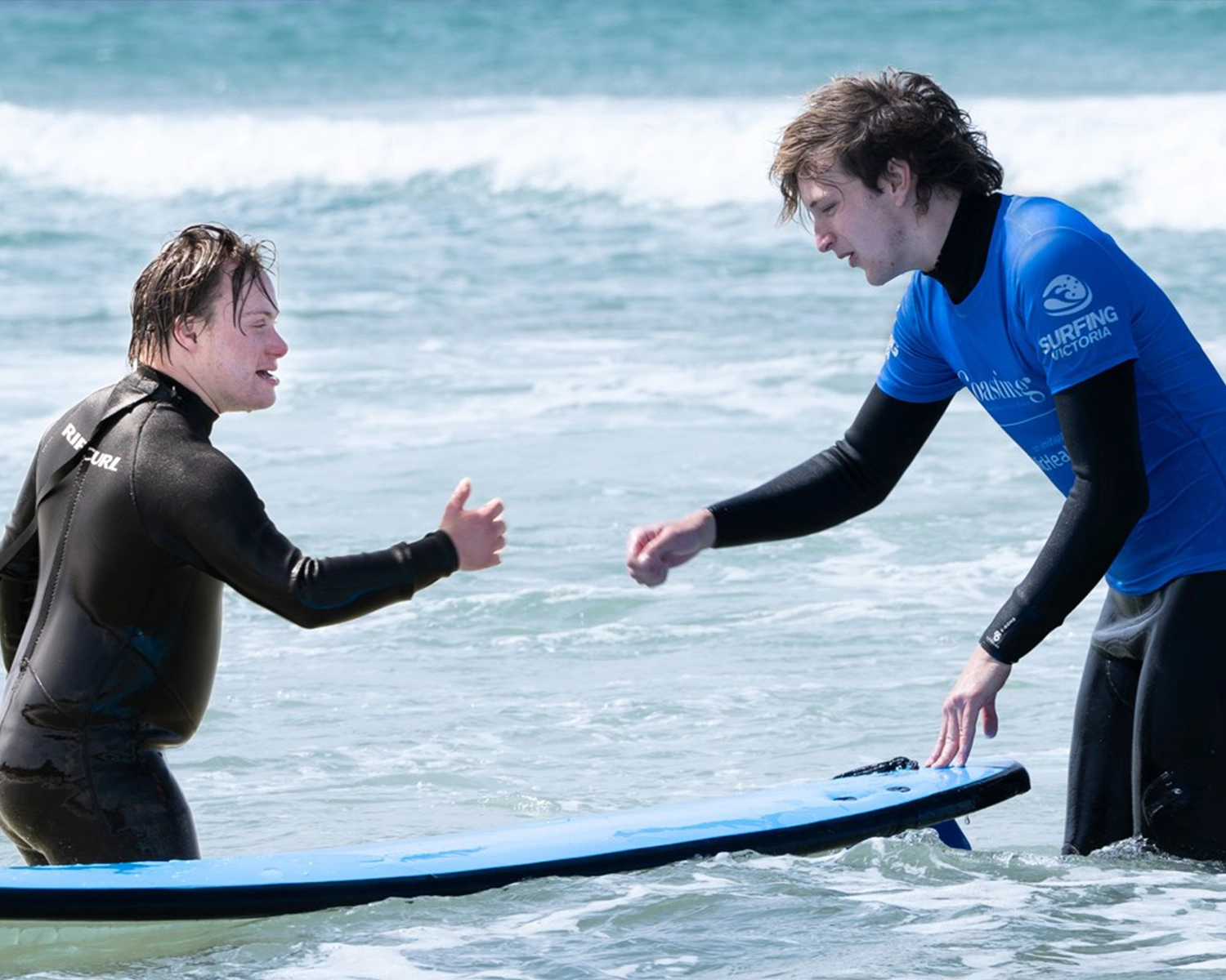 Partnerships Distinctive Options surfing at beach at NDIS registered disability support Distinctive Options
