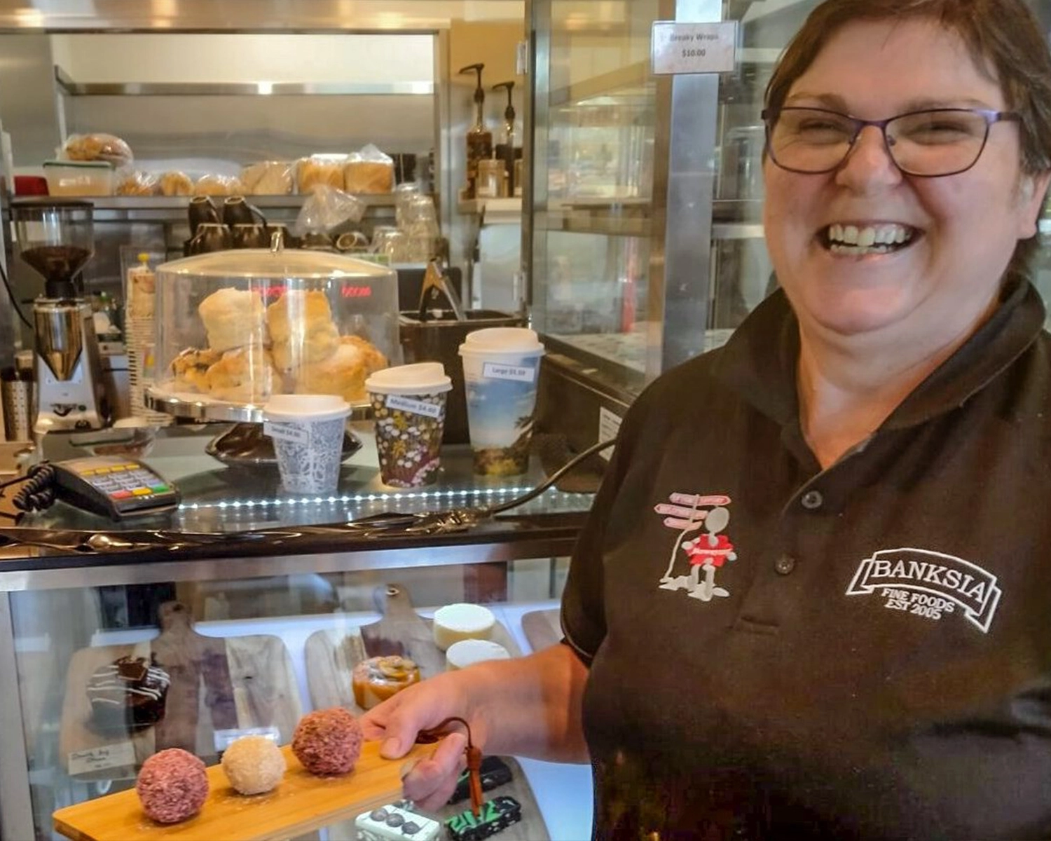 supported employee serving cakes at brew crew cafe at NDIS registered disability support Distinctive Options